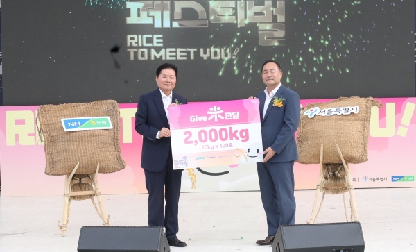 김병원 회장(왼쪽)이 김원이 서울특별시 정무부시장에게 농협 RPC운영전국협의회에서 기증한 쌀 2000kg을 전달하고 있다.